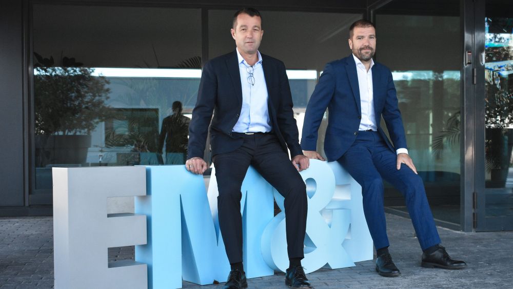 Los hermanos Escribano, Angel y Javier, en la entrada de su sede en Alcalá de Henares.